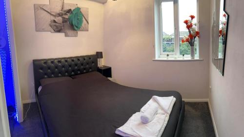 a bedroom with a black bed with a window at Sleek & Stylish - E15 Apartment With Parking in London