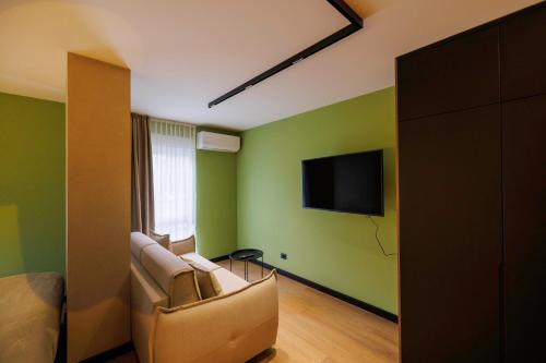 a living room with a couch and a flat screen tv at 1863 Boutique Hotel in Peje