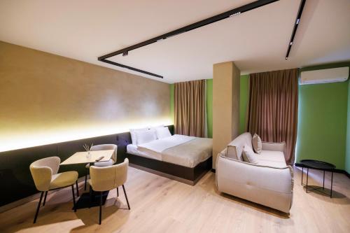a hotel room with a bed and a table and chairs at 1863 Boutique Hotel in Peje