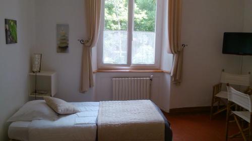 sypialnia z łóżkiem i dużym oknem w obiekcie Auberge Cocagne w mieście Avèze