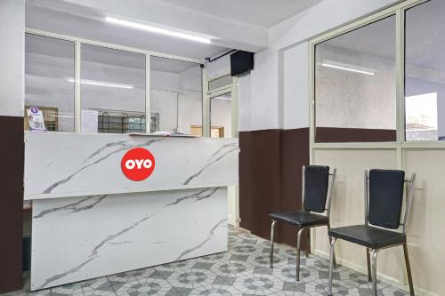 an office with two chairs and a counter with aoops sign at Hotel O Sai Avenue in Pune