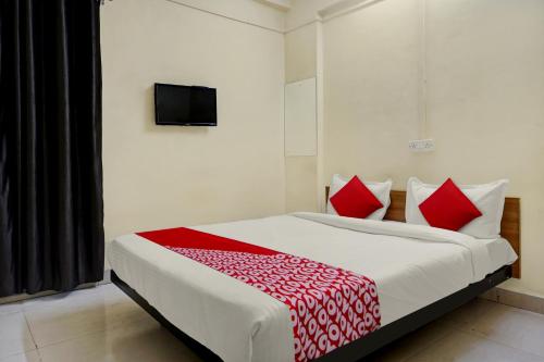 a bedroom with a large bed with red pillows at Sai Avenue in Hinjewadi