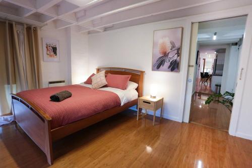 a bedroom with a bed with a red blanket at Seddon Studios in Melbourne