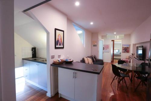 a kitchen and living room with a table and a dining room at Seddon Studios in Melbourne