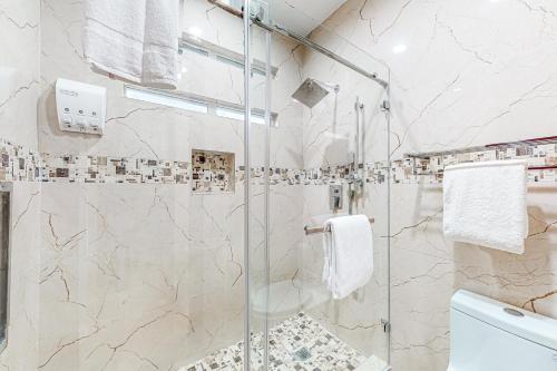 een badkamer met een douche en een glazen deur bij La Dolce Vita #302 in Phoenix