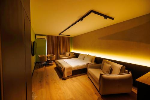 a hotel room with a bed and a couch and chairs at 1863 Boutique Hotel in Peje