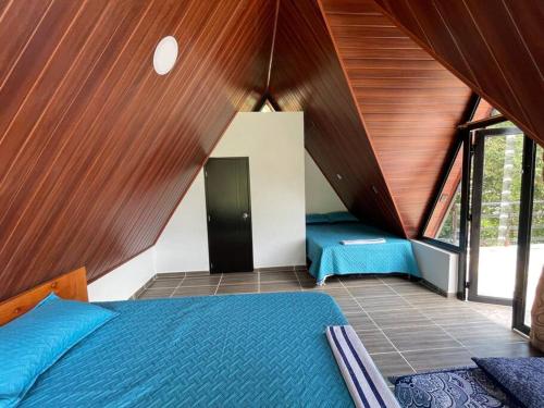 a bedroom with a bed and a wooden ceiling at Hermosa Cabaña cerca a Villeta in Quebradanegra