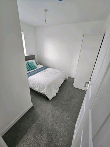 a bedroom with a bed in a white room at Darnley southside room in a private home 61 Leggastston Road in Pollokshaws