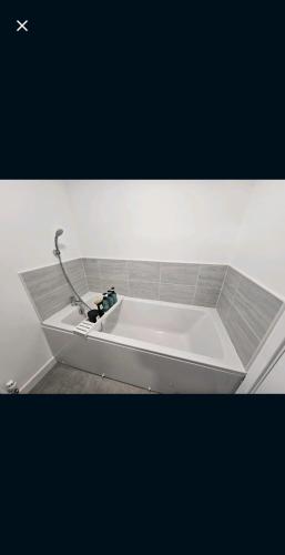 a white bath tub with a sink in a room at Darnley southside room in a private home 61 Leggastston Road in Pollokshaws