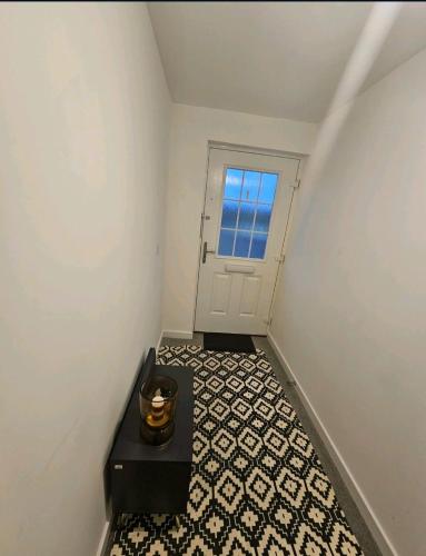 a hallway with a black table and a door at Darnley southside room in a private home 61 Leggastston Road in Pollokshaws
