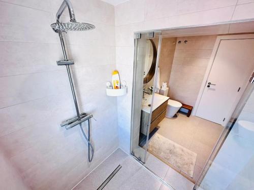 La salle de bains est pourvue d'une douche avec une porte en verre. dans l'établissement Lisbon City Center flat for 6 pp, à Lisbonne