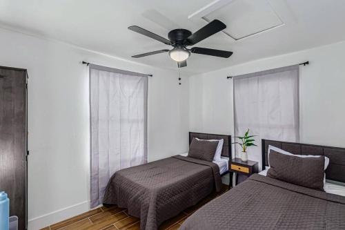 a bedroom with two beds and a ceiling fan at Phoenix Retreat - 2 Bedroom Home with King-Size Bed - 3 Smart TVs - 10 min from Airp - Unit A in Phoenix