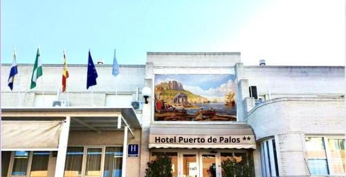 une fresque murale sur le côté d'un bâtiment arborant des drapeaux dans l'établissement Hotel Puerto de Palos (La Rabida), à Palos de la Frontera