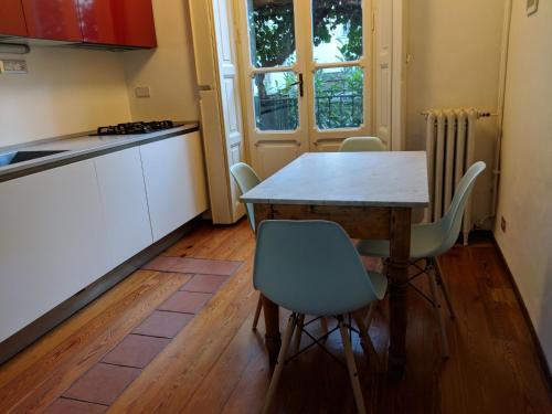 a kitchen with a wooden table and chairs in a kitchen at Atelier Relax Petit Turin - Centralissimo in Turin