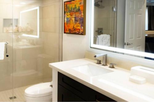 a bathroom with a sink and a toilet and a mirror at Super Bowl 2024 Las Vegas Apartment in Las Vegas