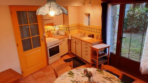 une petite cuisine avec une table et une salle à manger dans l'établissement La petite maison dans la prairie, à Cassaignes