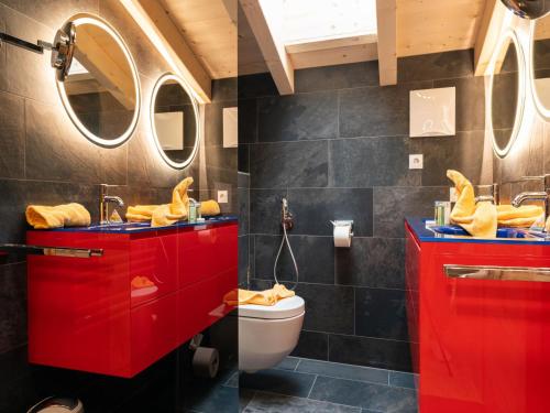 a bathroom with red cabinets and a toilet at Kaprun Lodge - R in Kaprun