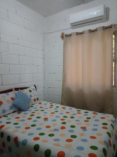 um quarto com uma cama com um cobertor de bolinhas em Casa Adelita em Barra de la Cruz