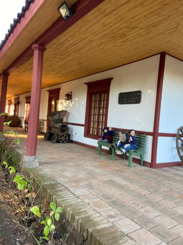 two people sitting on a bench outside of a building at CASONA SAN PEDRO Hotel Boutique in San Javier