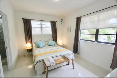 um quarto com uma cama com almofadas azuis e uma janela em 1 Stylish SoBe Condo 1/2 Block From The Beach!!! em Miami Beach