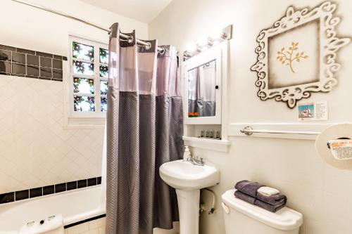 a bathroom with a sink toilet and a mirror at Casa Bonita Apartments in Long Beach