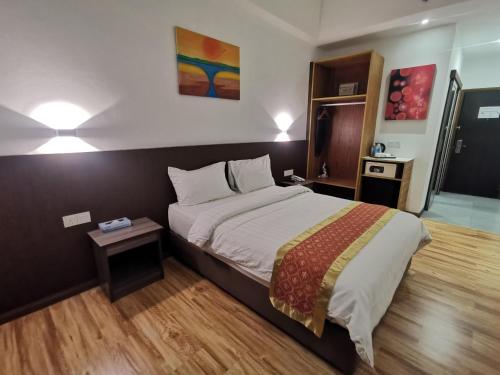 Sentral View Hotel Bintulu في بينتولو: غرفة نوم بسرير كبير وطاولة