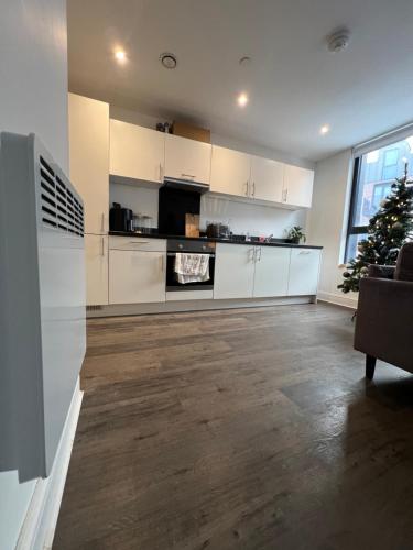 a large kitchen with white cabinets and a christmas tree at Stunning Modern Apartment in High Wycombe