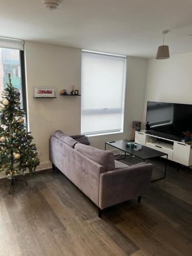 a living room with a couch and a christmas tree at Stunning Modern Apartment in High Wycombe