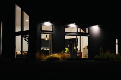 a person standing outside of a house at night at Stunning, Alpine House in Kingston