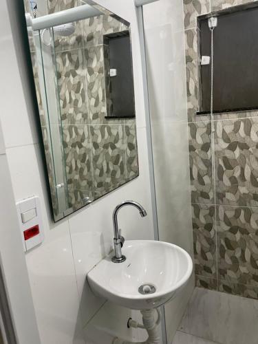 uma casa de banho com um lavatório e um espelho em Escondidinho Bar, hostel e casa de festas no Rio de Janeiro