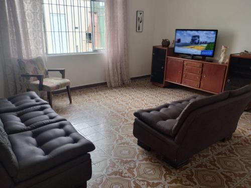 - un salon avec deux canapés et une télévision dans l'établissement Casa Harmonia, à Guarujá