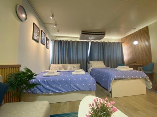 2 Betten in einem Zimmer mit blauer Bettwäsche in der Unterkunft PTJ Style Condotel คอนโดเมืองทอง P1 in Ban Song Hong