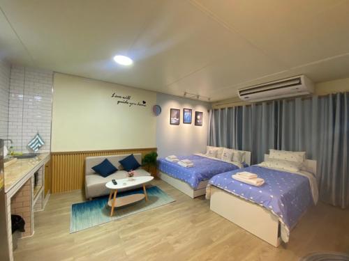 ein Hotelzimmer mit 2 Betten und einem Sofa in der Unterkunft PTJ Style Condotel คอนโดเมืองทอง P1 in Ban Song Hong