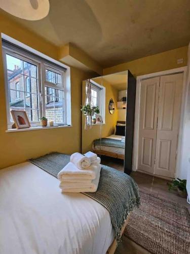 een slaapkamer met een bed met handdoeken erop bij West Kensington flat, balcony in Londen