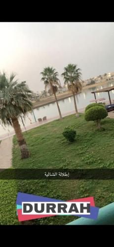 a picture of a park with palm trees and the ocean at درة العروس الحالمة in Durat  Alarous