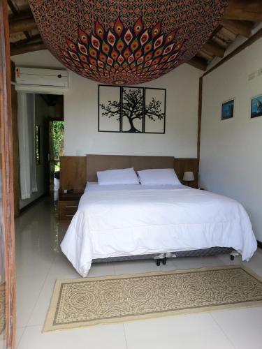 a bedroom with a large bed with a large ceiling at Chalé e Suite Manacá in Ubatuba