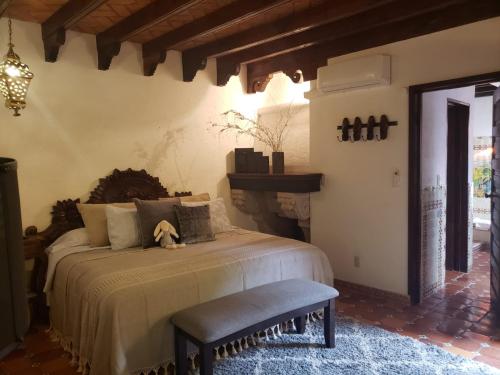 a bedroom with a bed with a dog sitting on it at Tres Fuentes Hotel Boutique in San Miguel de Allende