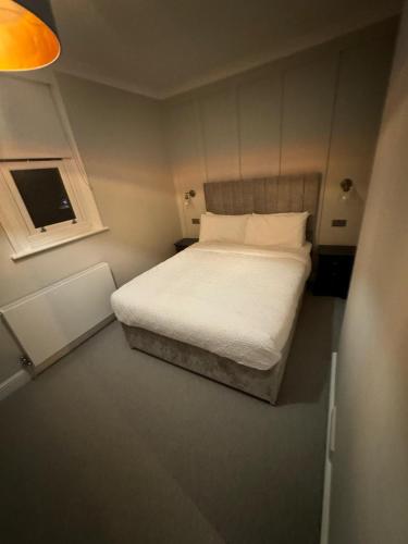 a small bedroom with a bed and a window at Premium Apartment in Redhill Town Centre in Redhill
