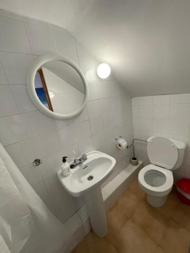 a bathroom with a sink and a toilet and a mirror at Apartamento cuco Finestrat in Finestrat