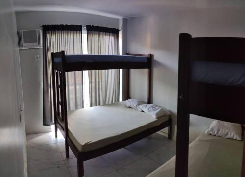 Un dormitorio con dos literas y una ventana. en CASA INDIVIDUAL CoM PISCINA, AR, WI-FI, ATÉ 16 PESSOAS, en Itapema