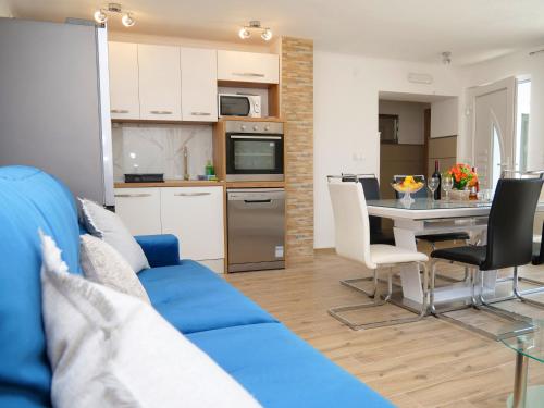 a living room with a blue couch and a kitchen at Family friendly house with a swimming pool Vinovac, Zagora - 22041 in Blizna Donja
