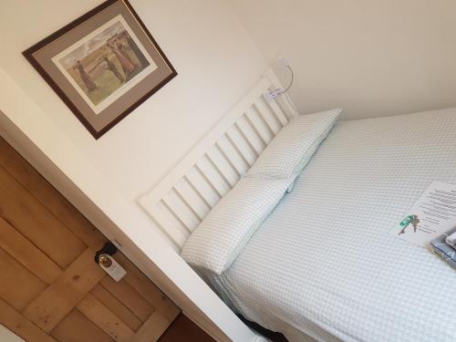 Un dormitorio con una cama blanca con una foto en la pared en One Home, en Oxford