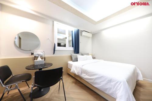 a bedroom with a bed and a table and a mirror at Number 25 Hotel in Gwangju