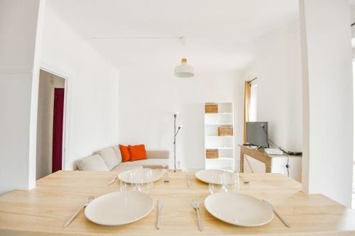 - deux plaques blanches sur une table en bois dans le salon dans l'établissement Le Schuman - Appart 1 ch proche Panier Vieux-Port, à Marseille