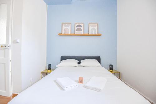 une chambre avec un lit blanc avec deux serviettes blanches dans l'établissement Le Schuman - Appart 1 ch proche Panier Vieux-Port, à Marseille