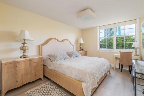 a bedroom with a bed with a dresser and a window at Spacious 3 Bedroom Condo in Aventura in Aventura