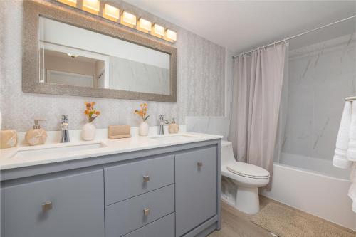 a bathroom with a sink and a toilet and a mirror at Spacious 3 Bedroom Condo in Aventura in Aventura