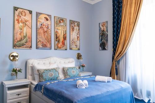 ein Schlafzimmer mit einem Bett mit vier Bildern an der Wand in der Unterkunft Zámek d´Este in Chlum u Třeboně