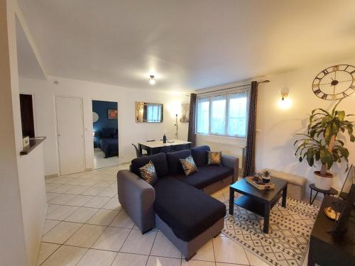 ein Wohnzimmer mit einem Sofa und einem Tisch in der Unterkunft LE CHIC ETHNIC DREUX 52m2 - 50 MIN DE PARIS - PARKING GRATUIT in Dreux