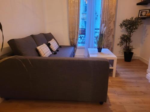 un salon avec un canapé et une table dans l'établissement Charmant appartement près de Montmartre 2, à Paris